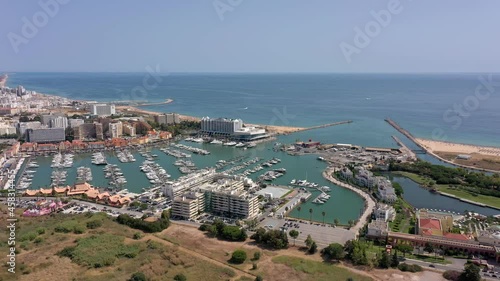 Aerial video of the tourist Portuguese town of Vilamoura, with views of the beaches and docks for luxury yachts, hotels and restaurants. Portugal, Algarve.