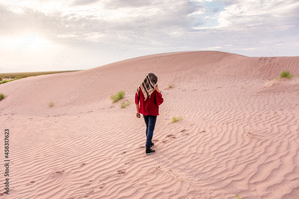 Unrecognizable Woman walking on desert dunes