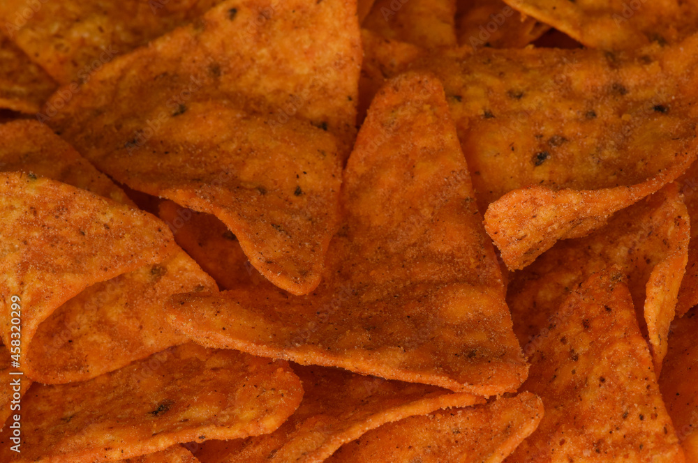 Corn nachos close up. Tortilla chips background. Spicy chips textured background.