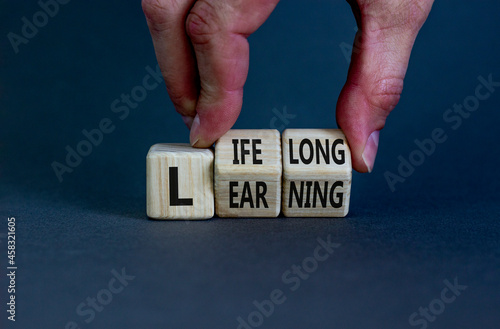 Lifelong learning symbol. Businessman turns wooden cubes with concept words 'Lifelong learning' on a beautiful grey background. Copy space. Business, educational and lifelong learning concept. photo