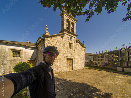 Caucasian male selfie with camera on forehead by Miraz church on santiago de compostela Pilgrimage photo