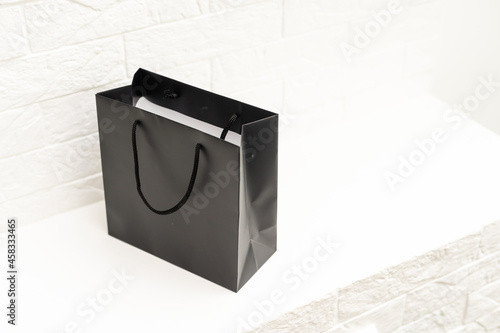 black paper bag with handles on a white background