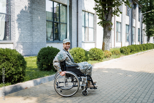 young handicapped veteran in wheelchair smiling on city street © LIGHTFIELD STUDIOS