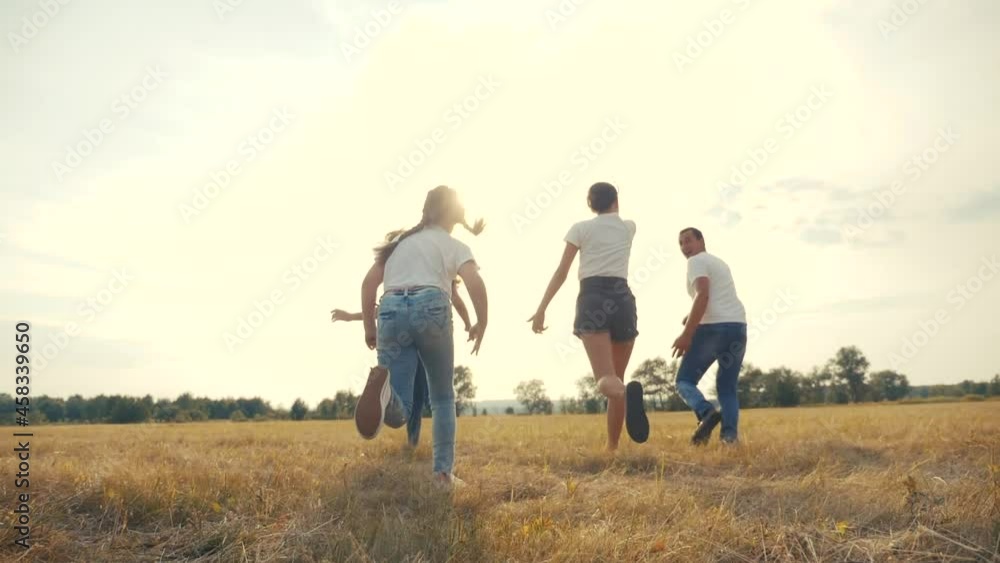 happy family children kids together run in park at sunset silhouette. people in park concept mom a dad daughter and son joyful run. parents and little baby child fun summer lifestyle vacation running