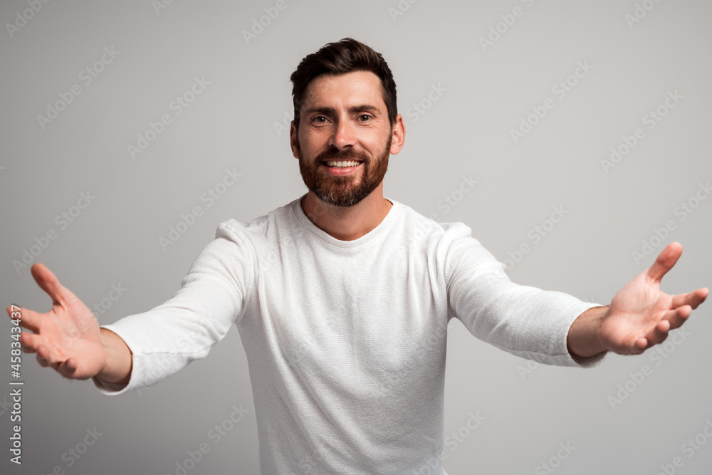 Open hearted generous man with beard sharing opening hands looking at camera with kind smile, greeting and regaling, happy glad to see you. Indoor studio shot isolated on white background Open hearted generous man with beard sharing opening hands looking at camera with kind smile, greeting and regaling, happy glad to see you. Indoor studio shot isolated on white background