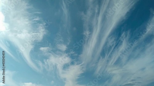 white cirrus-layered clouds in a blue sky can be usad as background, time lapse