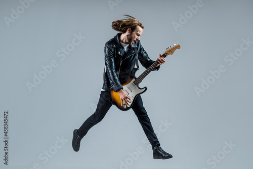 stylish crazy man. musical instrument. emotional bearded rocker in leather jacket. photo