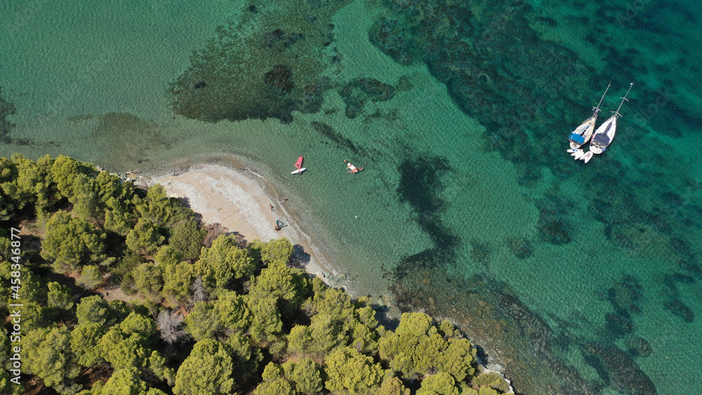 Aerial drone photo of famous bay and small traditional village of Atsitsa covered in pine trees and natural sandy beaches, Skiros island, Sporades, Greece
