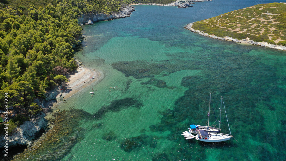 Aerial drone photo of famous bay and small traditional village of Atsitsa covered in pine trees and natural sandy beaches, Skiros island, Sporades, Greece