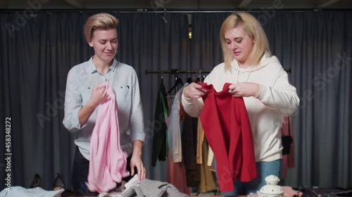 Wallpaper Mural Two happy women are folding clothes, putting things in order Torontodigital.ca