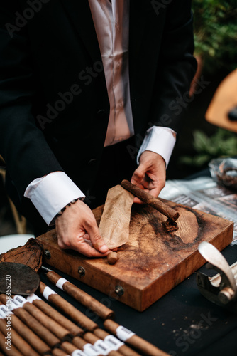 man rolling tobacco leaf into a cigar