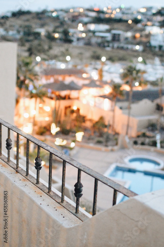 Vertical shot of a balcony on a resort with a view of pool and palm trees