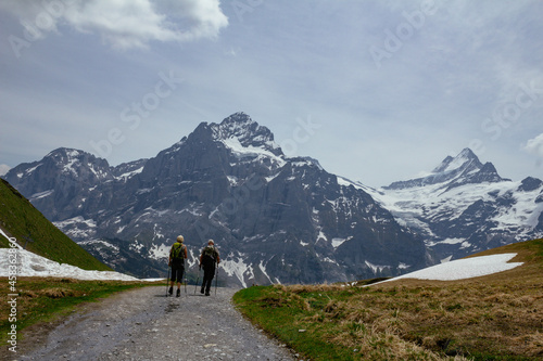 Backpacker hiker walking on panoramic trail with view on swiss alps with snow © Miguel