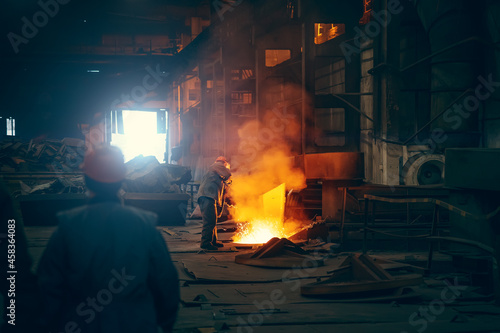 Worker in blast furnace. Metallurgical plant. Industrial steel production. Interior of metallurgical workshop. photo