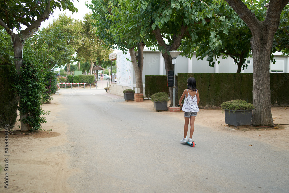 1 young girl riding scooters