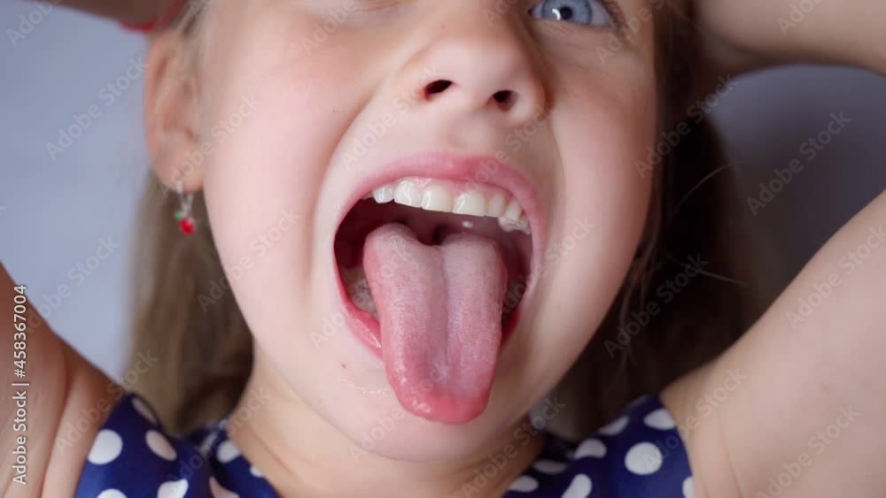 girl opens her mouth wide and pulls out long tongue. child ...   
