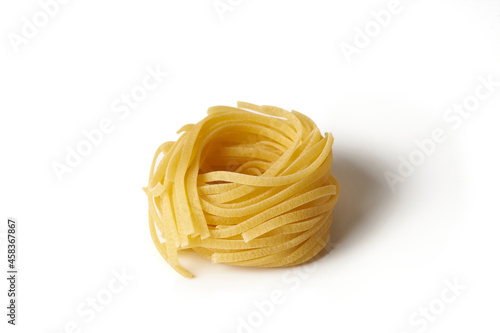 Rolled tagliatelle pasta isolated on white background