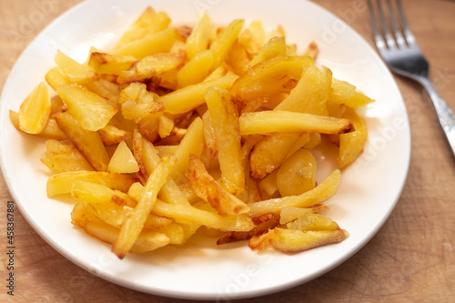 Fresh golden chips on a white plate. Delicious vegetable dish