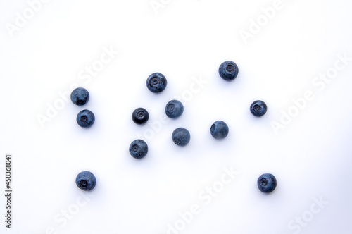 Flat lay composition with juicy, fresh blueberries. Isolated ecological ripe sweet bilberry fruits on white background. Copy Space. Top view of healthy organic summer vegetarian dessert food for diet