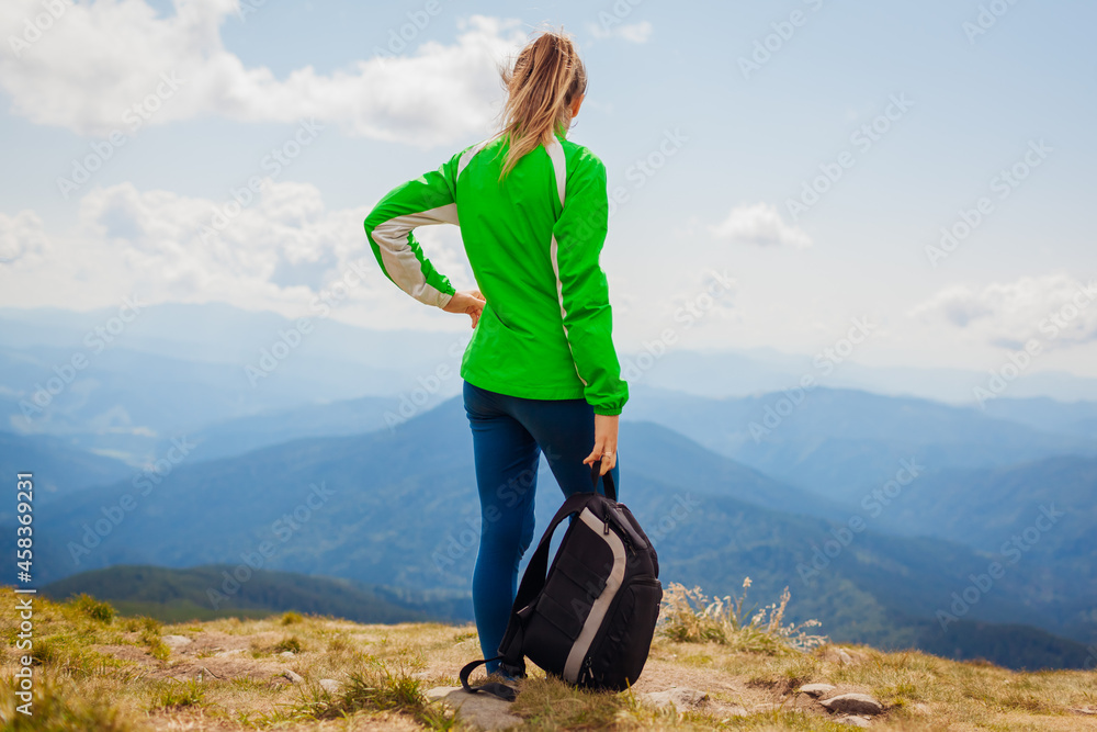 Trip to Carpathian mountains. Happy woman tourist hiker admires view on top of Hoverla. Traveling in summer Ukraine