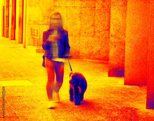 High-tech thermal imager. People and streets are traced by the temperature distribution of the studied surface (day and night). Sunny girl with dog and iphone photo