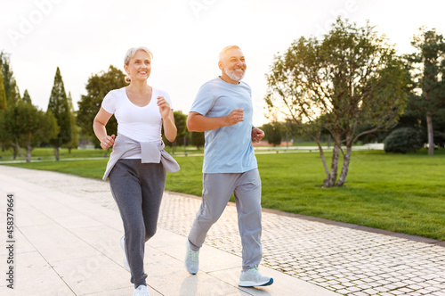 Photography Full-length photo of happy senior husband and wife in sportive outfits running o