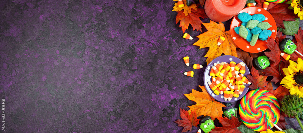 Halloween Trick or Treat Social Media Web Banner. Candy and lollipops, autumn leaves on stylish purple textured background. Top view blog hero header creative flat lay. Negative copy space. - obrazy, fototapety, plakaty 