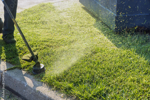 Close up on string trimmer head weed cutter brushcutter working in the yard cutting grass in garden