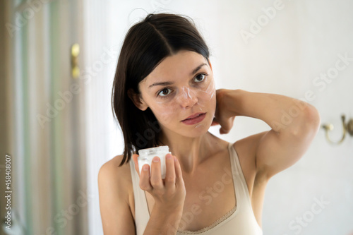 Woman applies a moisturizing cream.