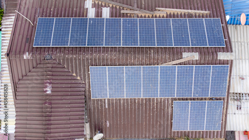 Old Solar panels on houseroof from aerial view. photo
