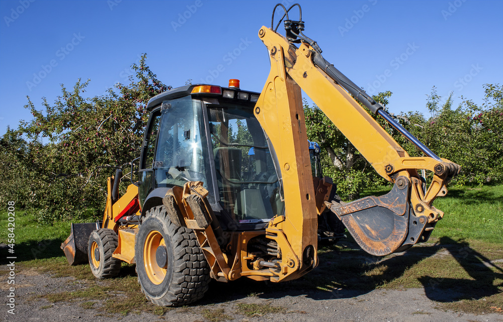 Excavator Tractor in an Apple Orchard, Auteuil, Laval, Quebec, Canada Excavator Tractor in an Apple Orchard, Auteuil, Laval, Quebec, Canada