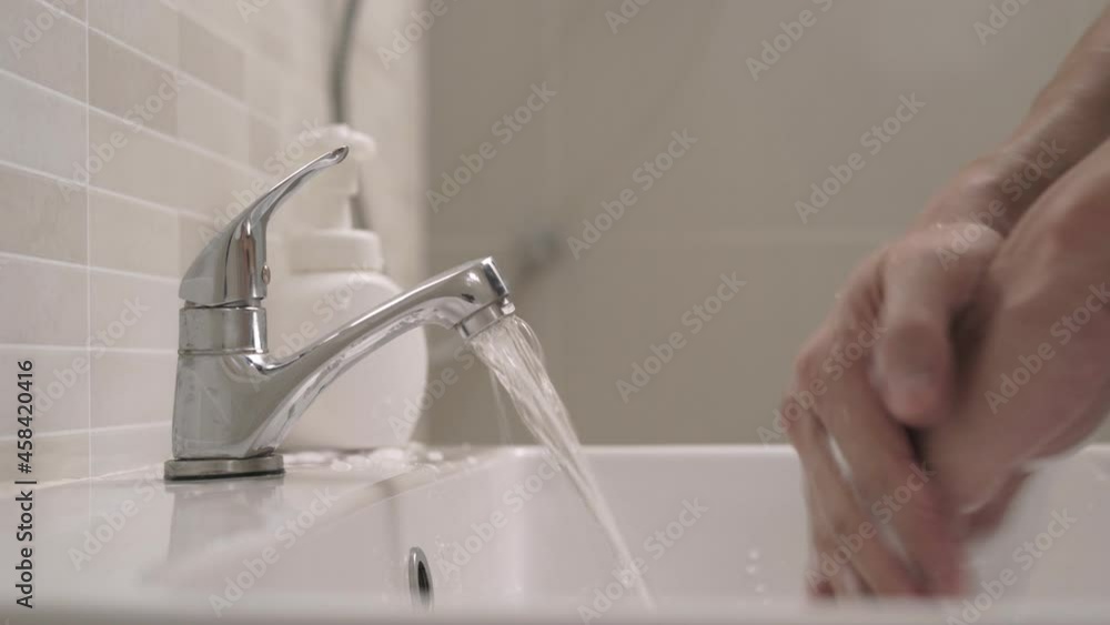 clean is method to prevent germs concept. man washing his hands after handling an object to prevent infection with the virus. Washing your hands frequently reduces the risk of contracting the virus. clean is method to prevent germs concept. man washing his hands after handling an object to prevent infection with the virus. Washing your hands frequently reduces the risk of contracting the virus.