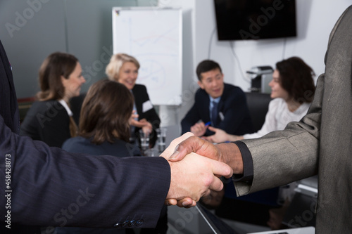 Closeup of international businessmen handshake on blur meeting room background