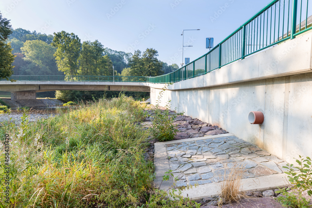 A new bridge across a small river. Summer time. 
Small reinforced concrete bridge after reconstruction. New asphalt.