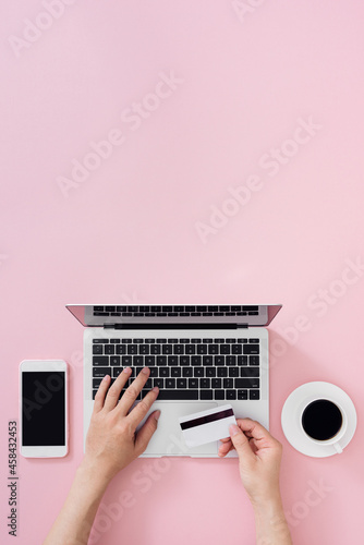 Top view of businessman office desk with credit card for online payment on laptop computer  flat lay on color background