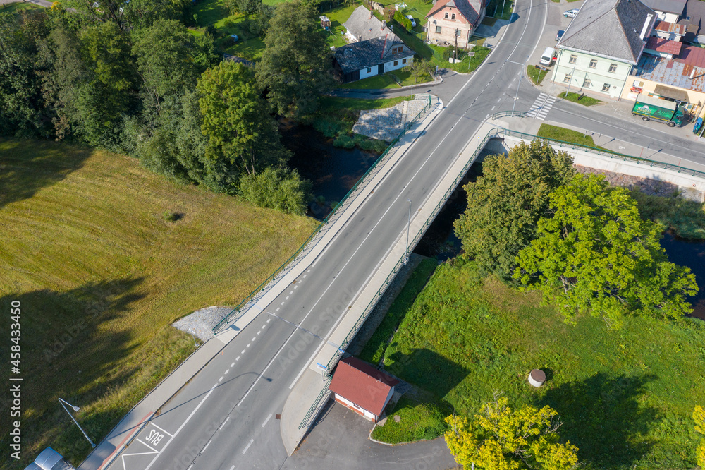 A new bridge across a small river. Summer time. 
Small reinforced concrete bridge after reconstruction. New asphalt.