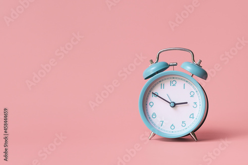 Alarm clock. Classic watch on a pink background.