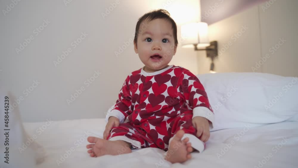portrait of asian baby infant 8 months old playing on bed at home. happy innocence baby kid smile happily. sucking hand age baby portrait crawling copy space provided. smiling baby laugh in bedroom. portrait of asian baby infant 8 months old playing on bed at home. happy innocence baby kid smile happily. sucking hand age baby portrait crawling copy space provided. smiling baby laugh in bedroom.