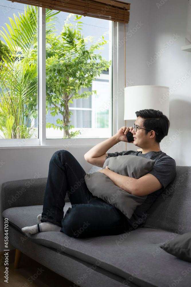 Happy casual man sitting on sofa and talking on mobile phone. Happy casual man sitting on sofa and talking on mobile phone.