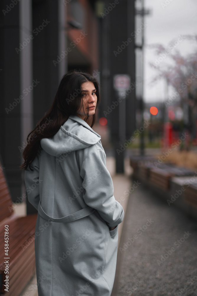 Portrait of brunette woman in the business downtown of modern city. Girl with long hair turn around and looking in camera. Business woman with trafic city lights in the background. Portrait of brunette woman in the business downtown of modern city. Girl with long hair turn around and looking in camera. Business woman with trafic city lights in the background.