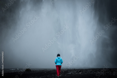 Woman admiring Skogafoss waterfall in Iceland