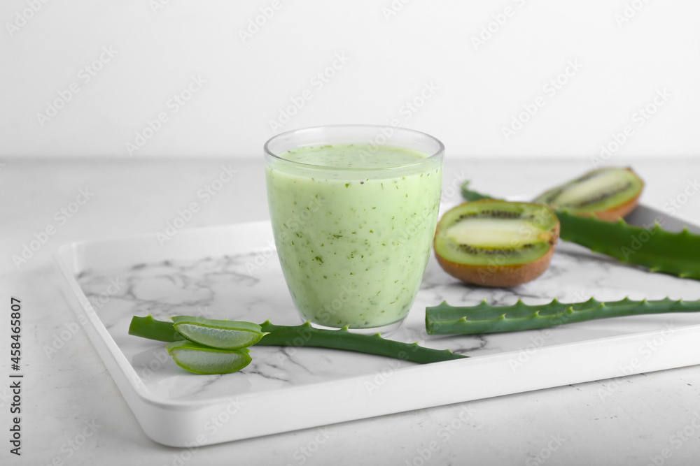 Tray with glass of healthy aloe juice on white background Tray with glass of healthy aloe juice on white background