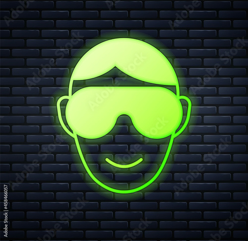 Glowing neon Eye sleep mask icon isolated on brick wall background. Sleeping mask. Vector