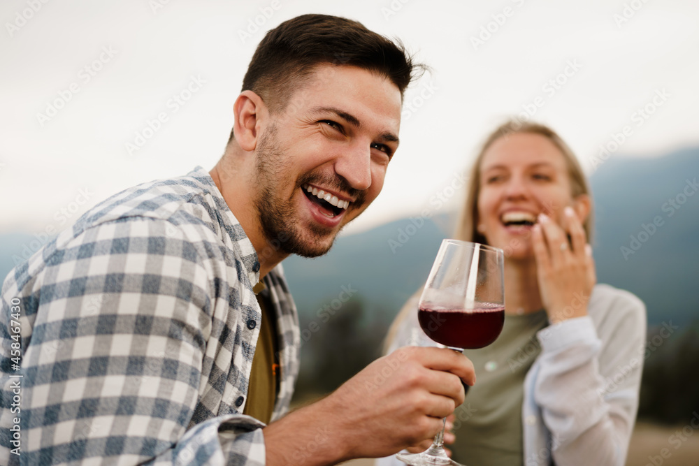 Smiling couple toasting wine glasses outdoors in mountains Smiling couple toasting wine glasses outdoors in mountains