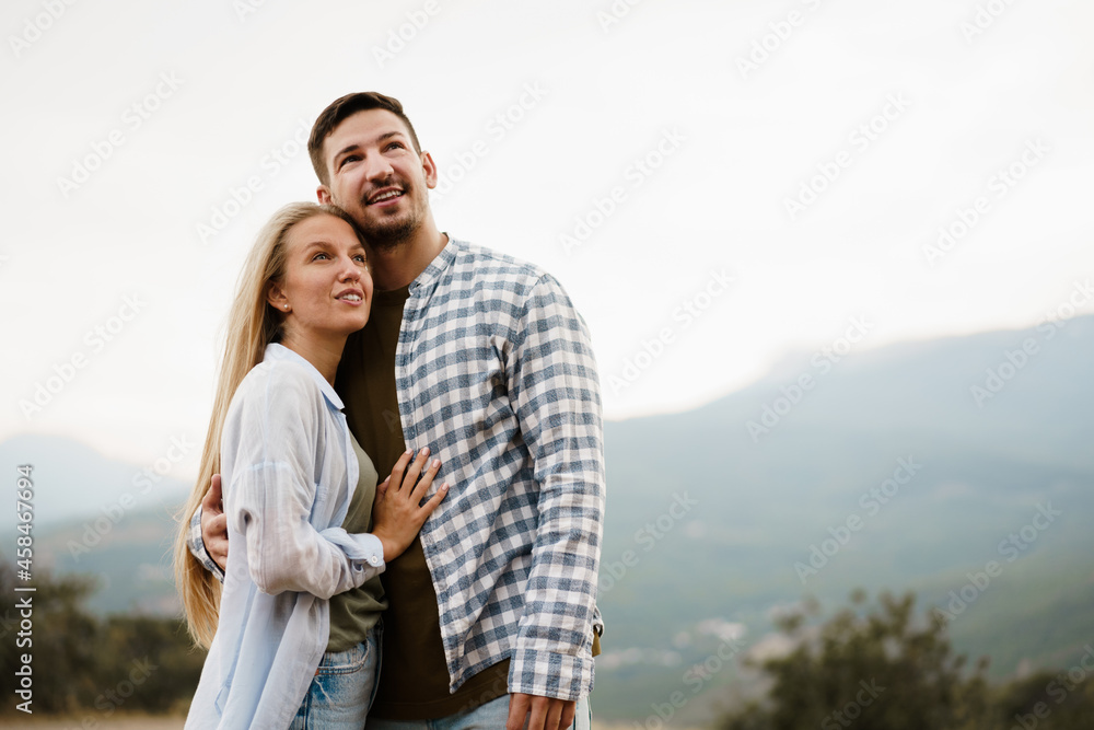 Happy loving couple hiking and hugging in mountains Happy loving couple hiking and hugging in mountains