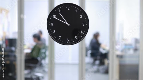 Time-lapse video 9AM-4.30PM office hours businesspeople does routine job in business time. Focus on watch moving from morning start to quit in afternoon shows company employees work in working room.
