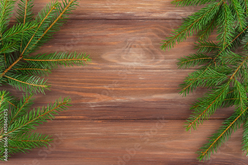 Fir branches on a wooden background. Christmas and New Year concept. Horizontal orientation, copy space, top view.