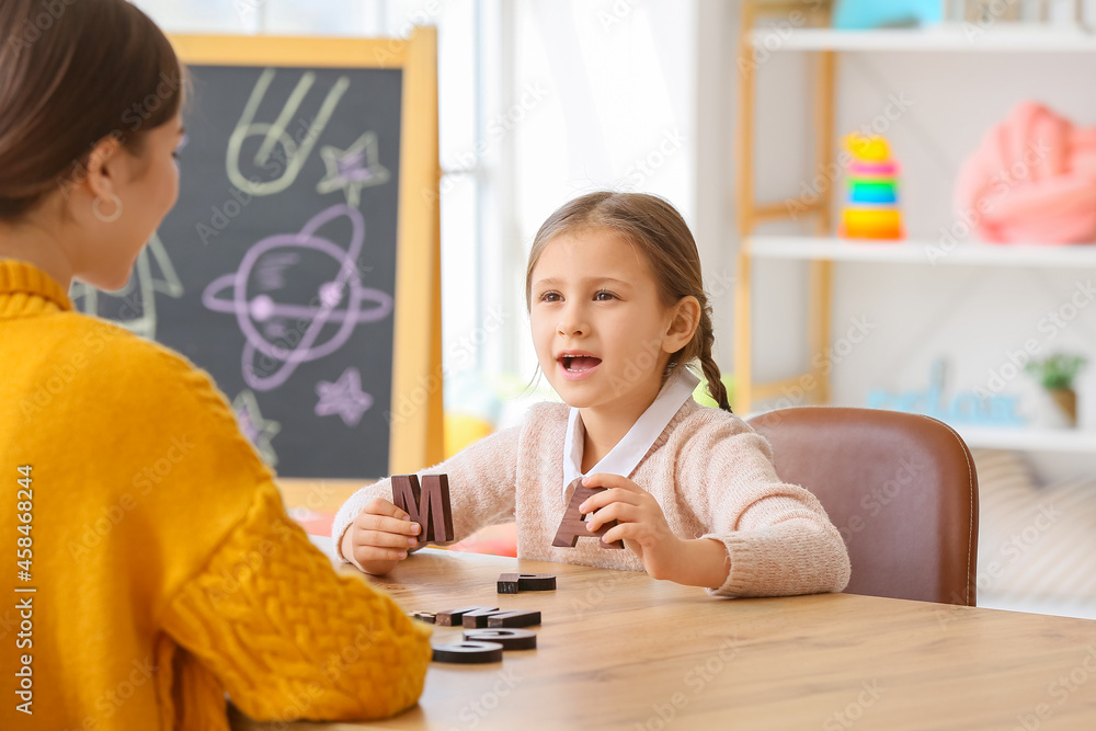 Speech therapist working with cute girl in clinic Speech therapist working with cute girl in clinic