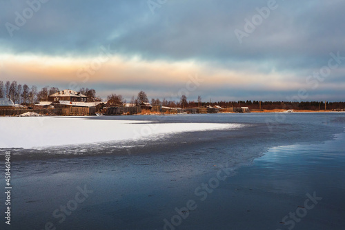 winter view with old houses near a snow-covered lake. Authentic Northern city of Kem in winter