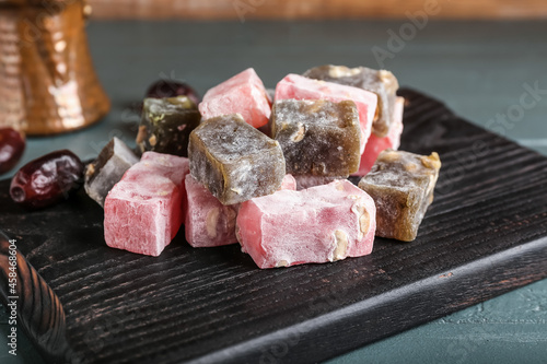 Board with sweet Turkish delight on grey wooden background